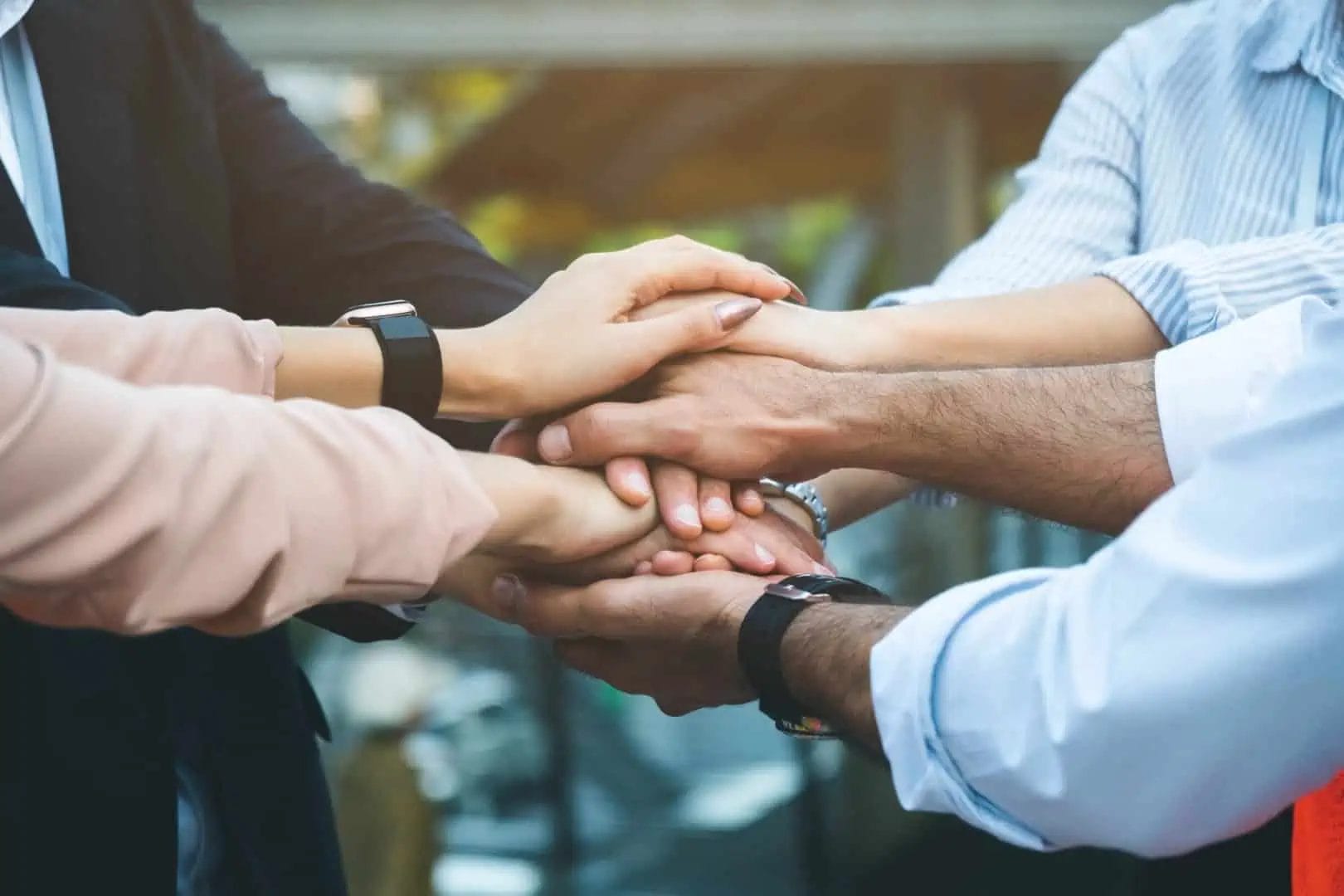 An image of group of people holding hands to as an indication of commitment